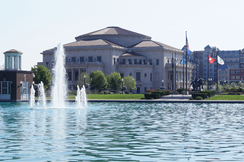 A decorative fountain sprays water into the air in front of The Palladium in Carmel, Indiana