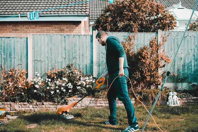 A person overgrown grass in backyard