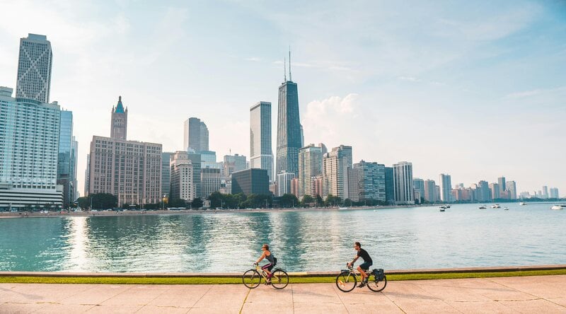 Two people riding bikes with Chicago skyline in the background