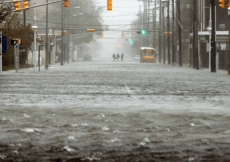 People walk down a flooded street in Atlantic City, New Jersey
