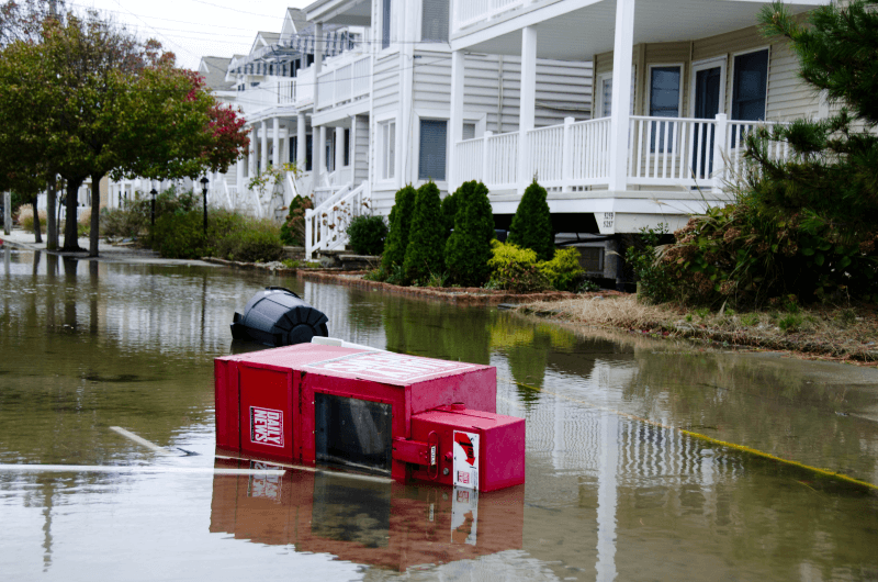 A newspaper stand is toppled over in standing water on a flooded street in Ocean City, New Jersey