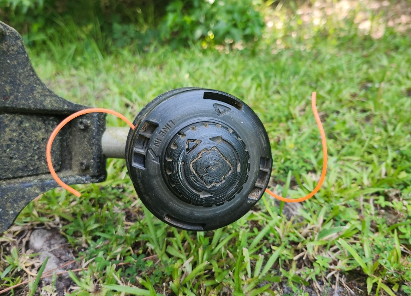 closeup of enhulk string trimmer with grassy background