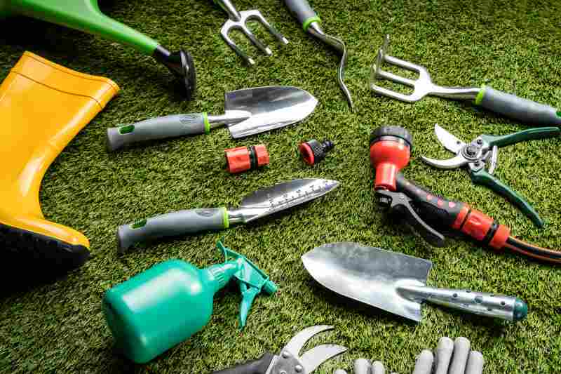 Various Gardening Tools And Boots Laying On Grass