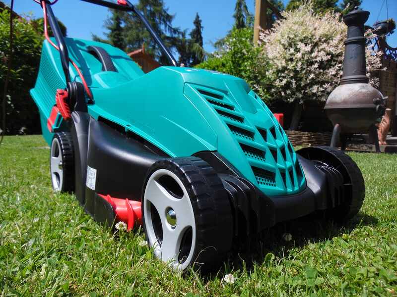 A teal-colored electric corded lawn mower