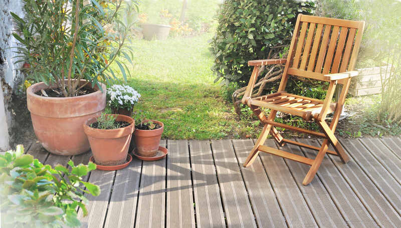 A chair and potted plants on a wooden terrace