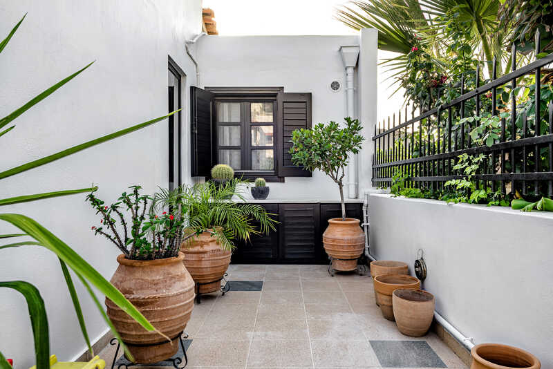 A white tiled terrace with potted plants