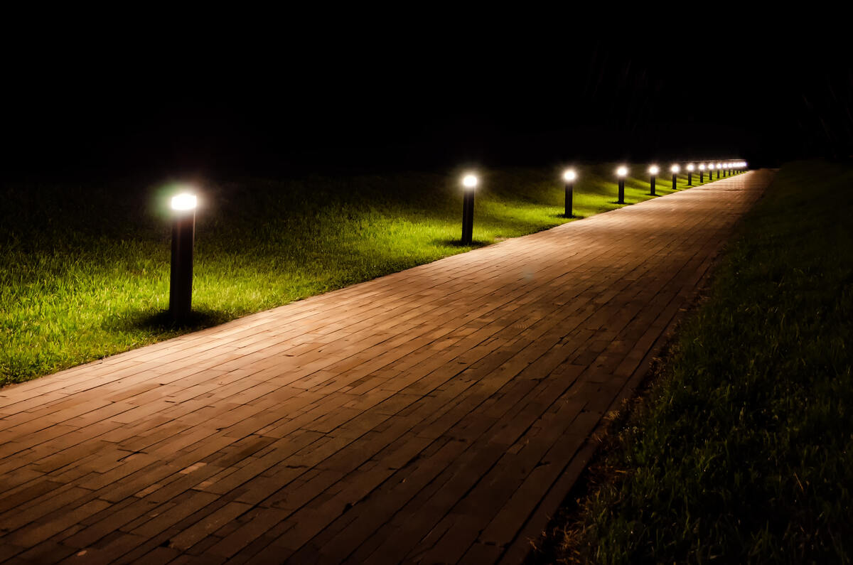 Lights in grass along a wood plank path